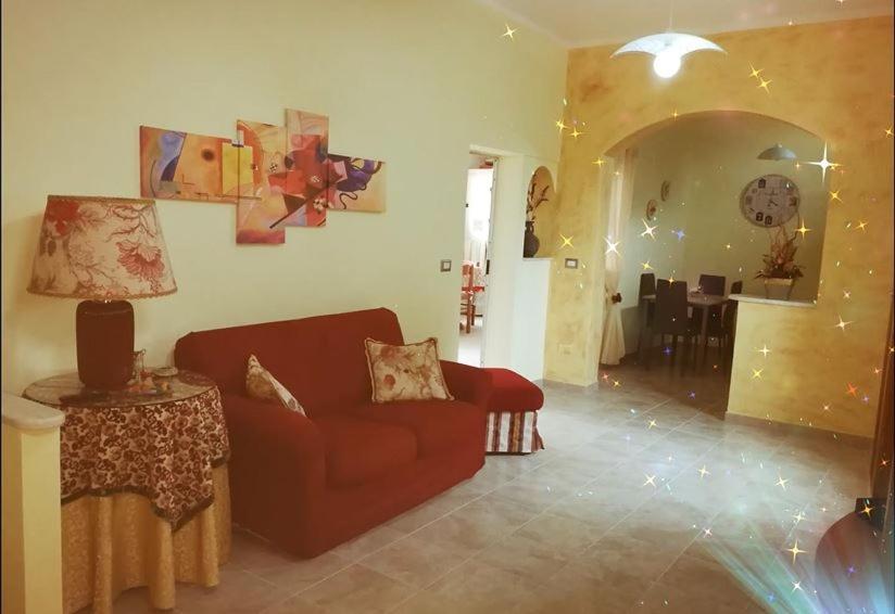 Casa Debby في بورتو توريس: غرفة معيشة مع أريكة حمراء وطاولة