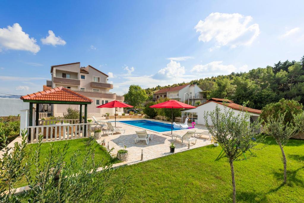 eine Villa mit einem Pool und einem Haus in der Unterkunft APARTMENTS ANA in Umljanović
