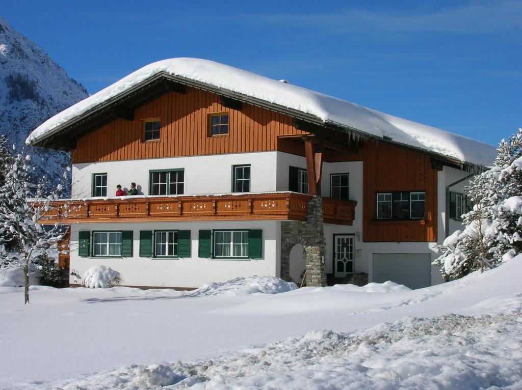 een huis met een met sneeuw bedekt dak bij Gästehaus Auer in Holzgau