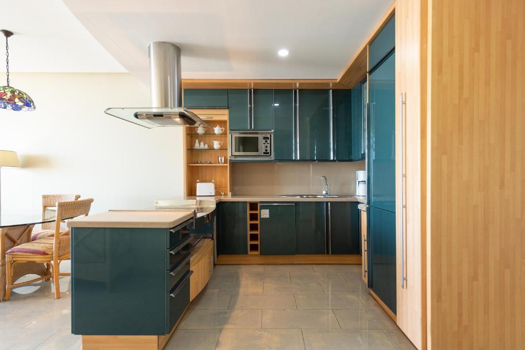 a kitchen with green cabinets and a counter top at Holiday Club Jardin Amadores in Amadores