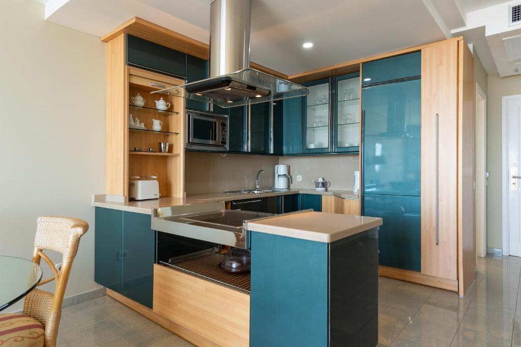 a kitchen with blue cabinets and a sink at Holiday Club Jardin Amadores in Amadores