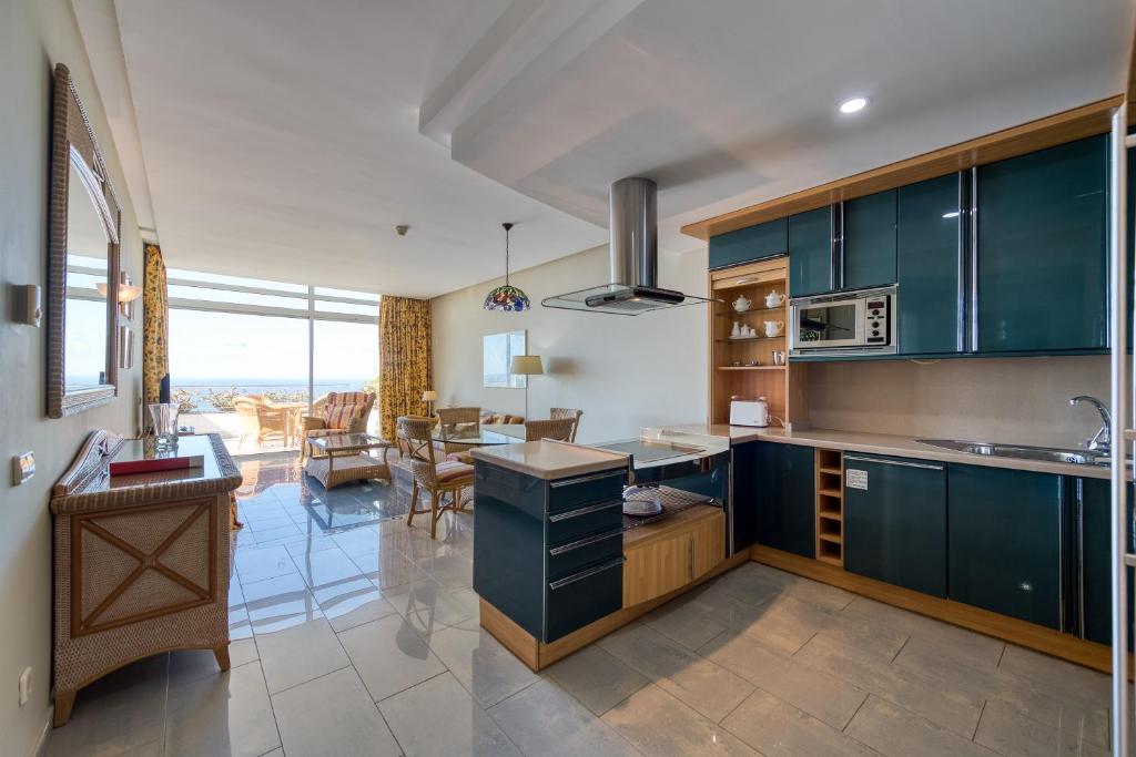 a kitchen with blue cabinets and a dining room at Holiday Club Jardin Amadores in Amadores