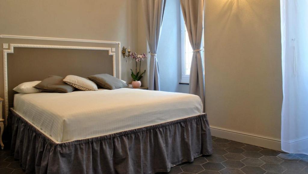 a bedroom with a large bed with a window at Locanda San Tomaso Affittacamere in Pietra Ligure