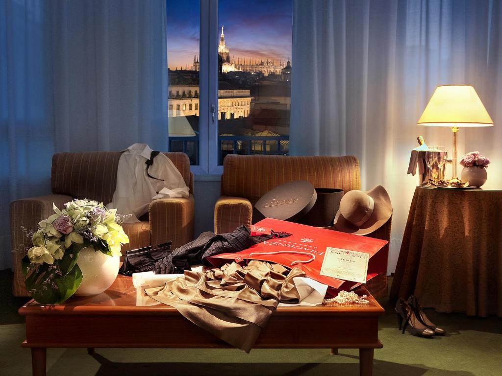 米蘭的住宿－卡沃爾酒店，客厅配有带衣服的桌子