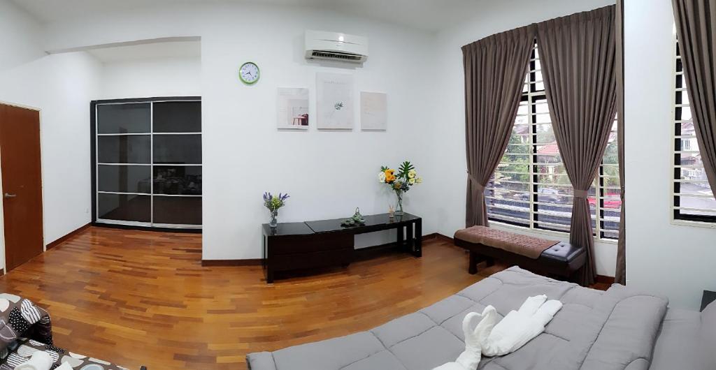 a living room with a couch and a large window at 12 Pax Puteri 6 Puchong Table Tennis/TV Game in Puchong