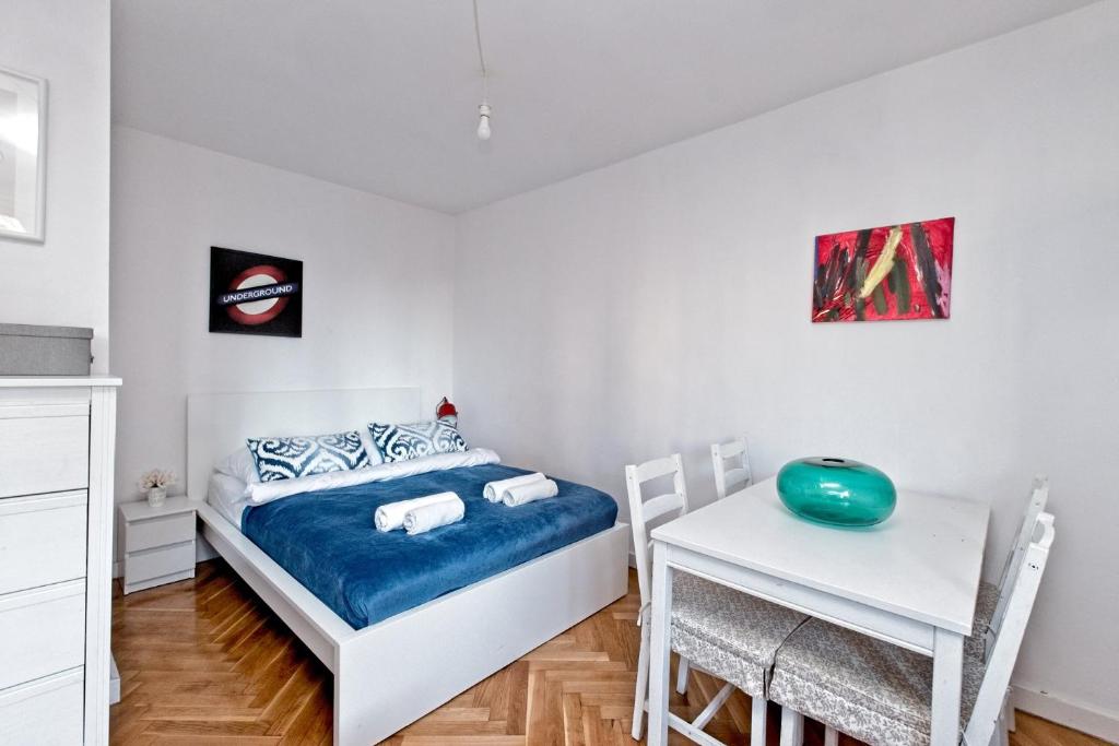 ein kleines Schlafzimmer mit einem Bett und einem Schreibtisch in der Unterkunft Noctis Apartment Pańska III in Warschau
