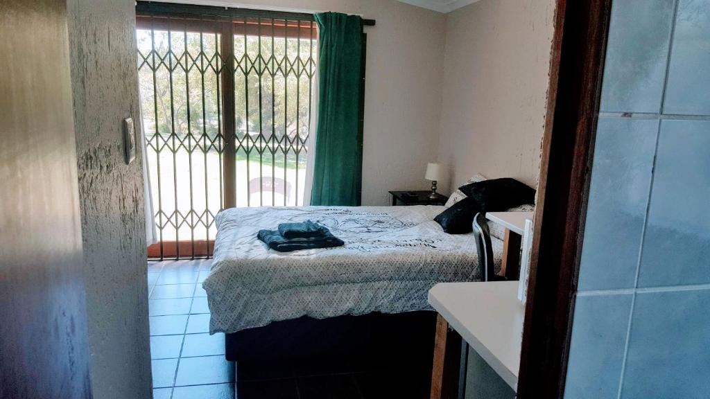 ein kleines Schlafzimmer mit einem Bett und einem Fenster in der Unterkunft Bachelor Apartment 2 in Midrand