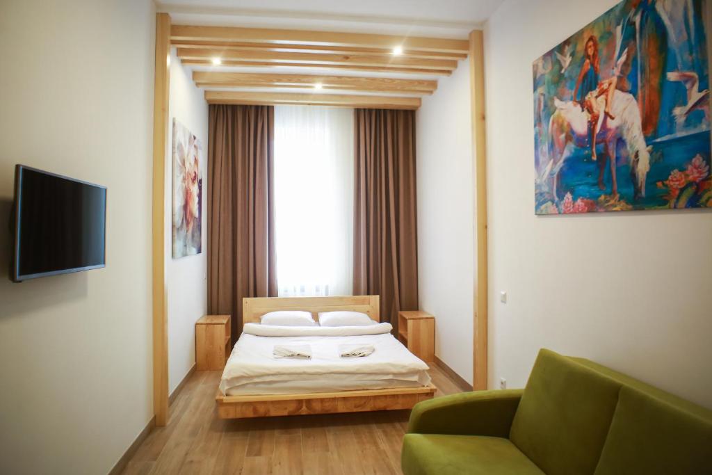 リヴィウにあるLEOGRAND Apartment on Drohobychaのベッドルーム(ベッド1台、緑のソファ付)