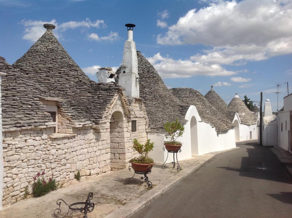a stone building with a clock on the side of it at Tipico Resort in Alberobello