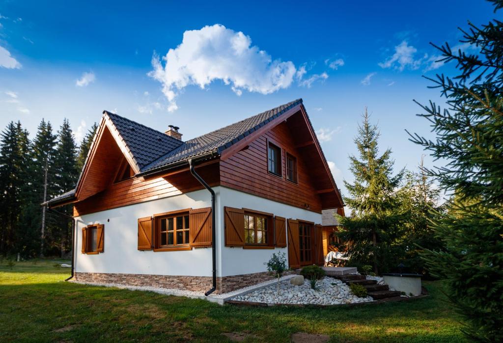 una pequeña casa con techo de gambrel en Chata Lienka en Lazisko