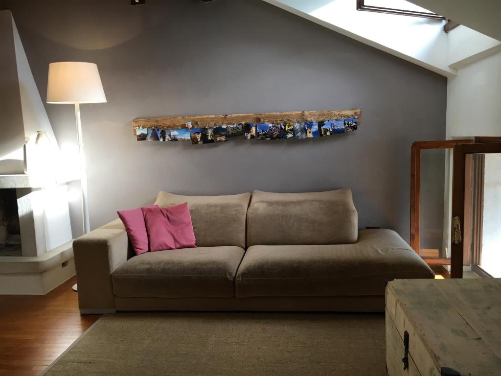 A casa di Checco في فيلتري: غرفة معيشة مع أريكة بنية ومخدة وردية