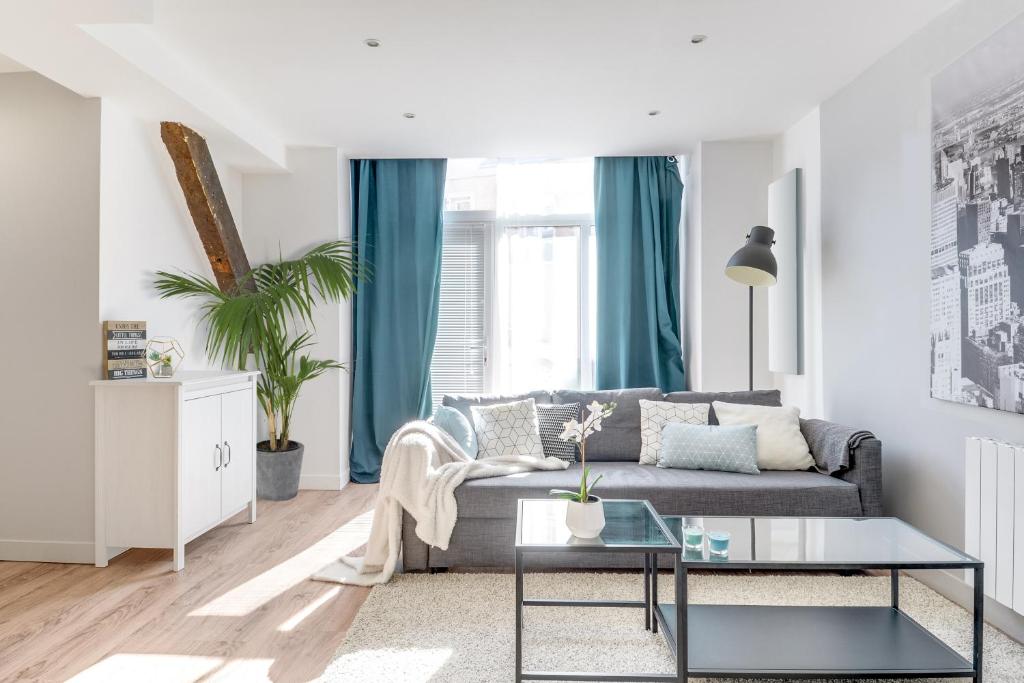 a living room with a couch and a table at Freedomus Marne-La-Vallée "Côté Loft" in Esbly