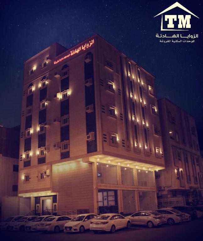 a building with cars parked in front of it at شقق الزوايا الهادئه للشقق المخدومة - اقتصادي - Alzwaya Alahadea Apartments in Jeddah