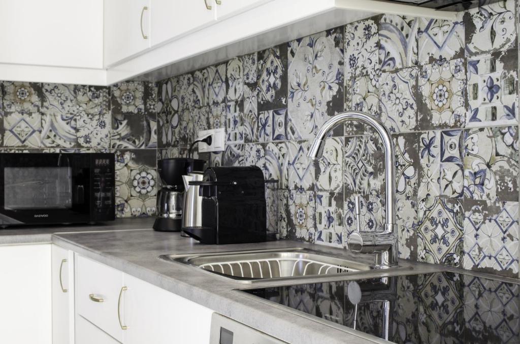 a kitchen with a sink and a microwave at Talos Luxury Suites in Kounoupidhianá