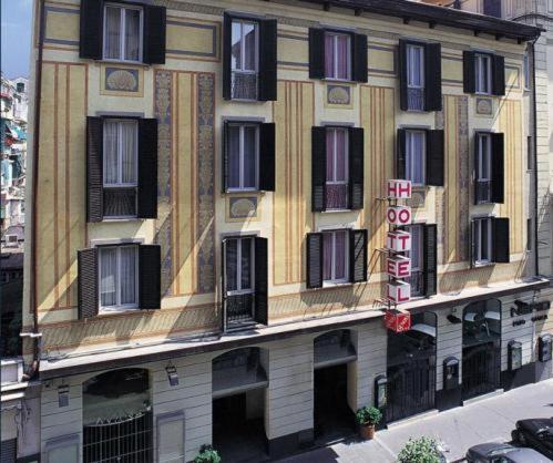 un grande edificio con finestre nere e un cartello sopra di Hotel Genova a La Spezia