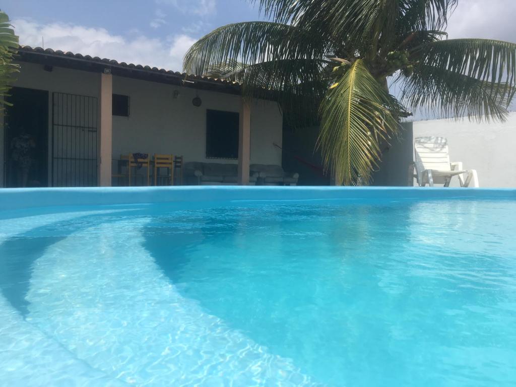 a large blue swimming pool in front of a house at Casa Praia Lagoa dos Tambaquis - Abaís in Estância