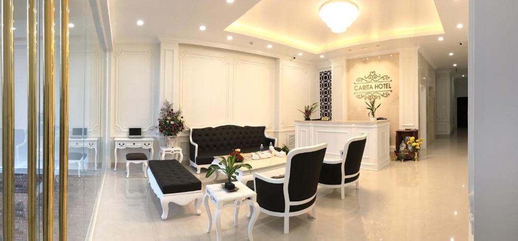 sala de estar con sofá, mesa y sillas en Carita Hotel en Dalat