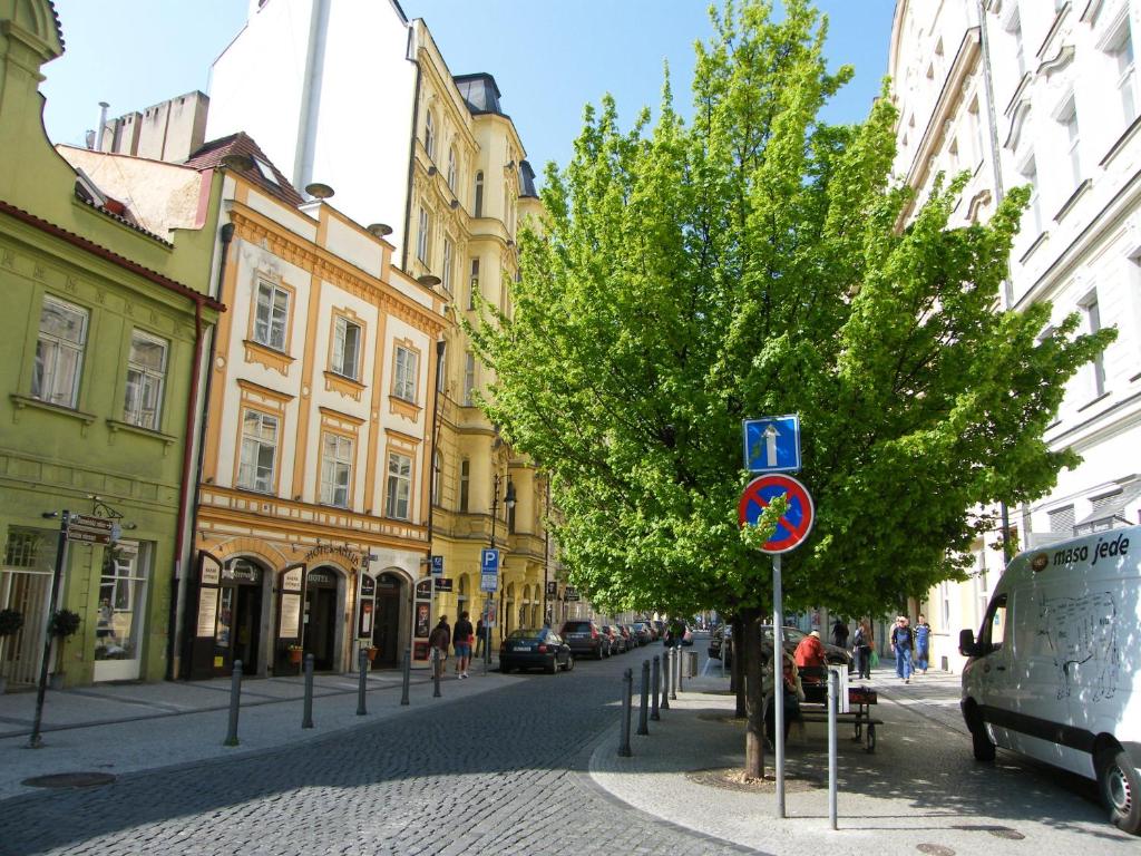 une rue avec un arbre et un panneau bleu sur une rue dans l'établissement Antik Hotel Prague, à Prague