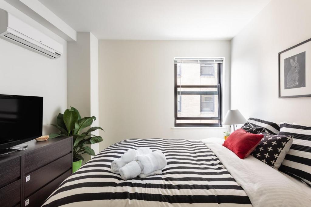 1 dormitorio con 1 cama en blanco y negro y TV en Uptown Gem en Chicago