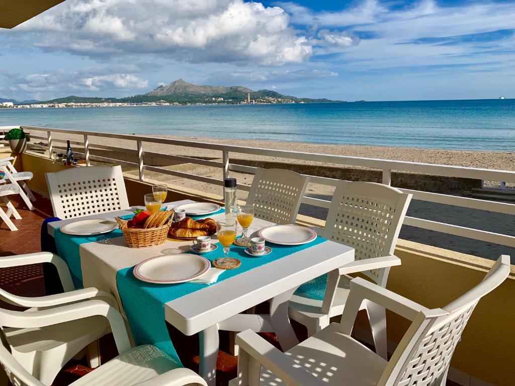 a table and chairs on a balcony with a view of the beach at El Paraiso in Alcudia