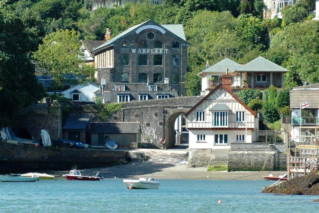 a group of boats in the water in front of a building at No1 The Pottery, Dartmouth in Dartmouth