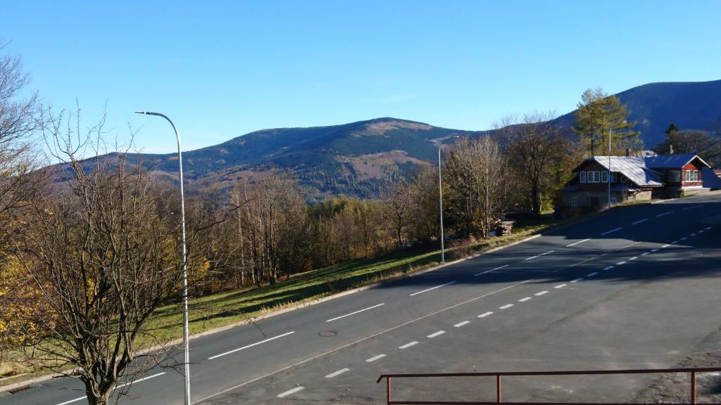 un camino vacío con una luz de la calle y montañas en el fondo en Karkonoska 41 en Karpacz