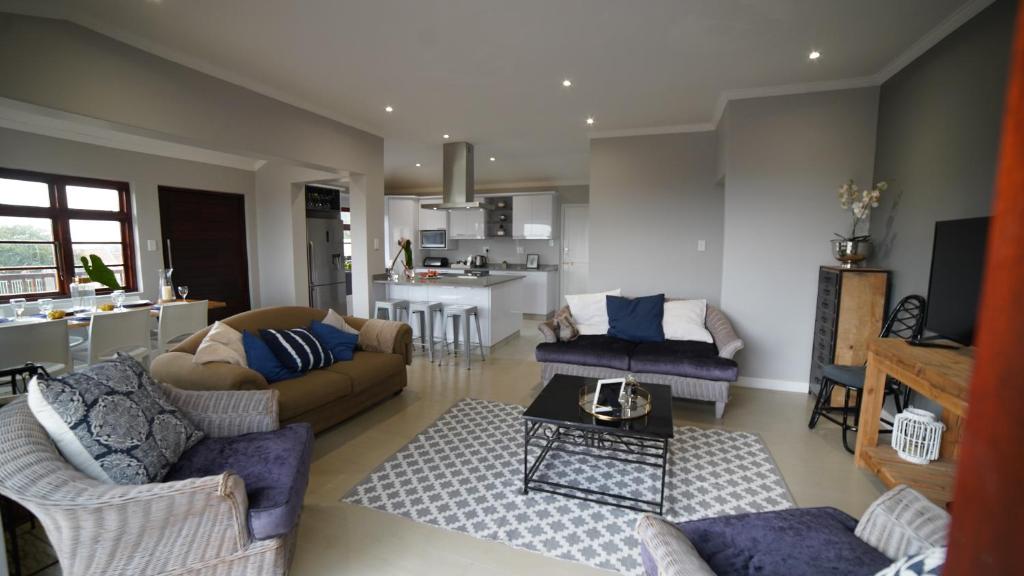 ein Wohnzimmer mit 2 Sofas und einer Küche in der Unterkunft Villa 93 in Durban