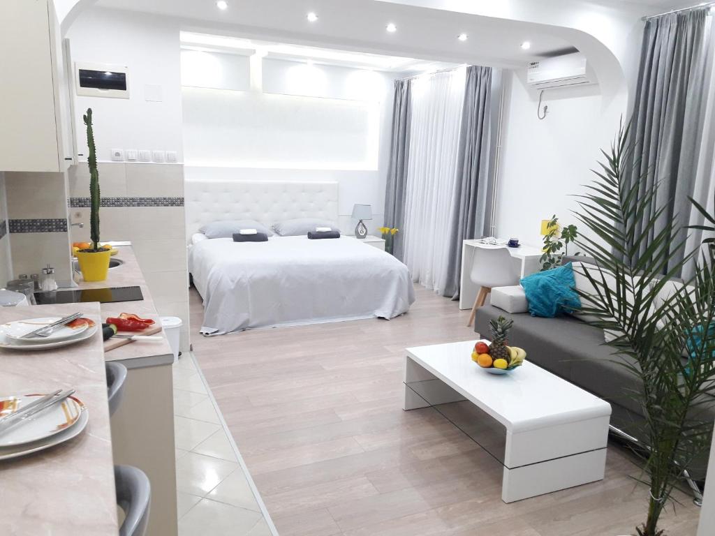 uma sala de estar branca com uma cama e um sofá em Apartmani Abbazia em Banja Luka