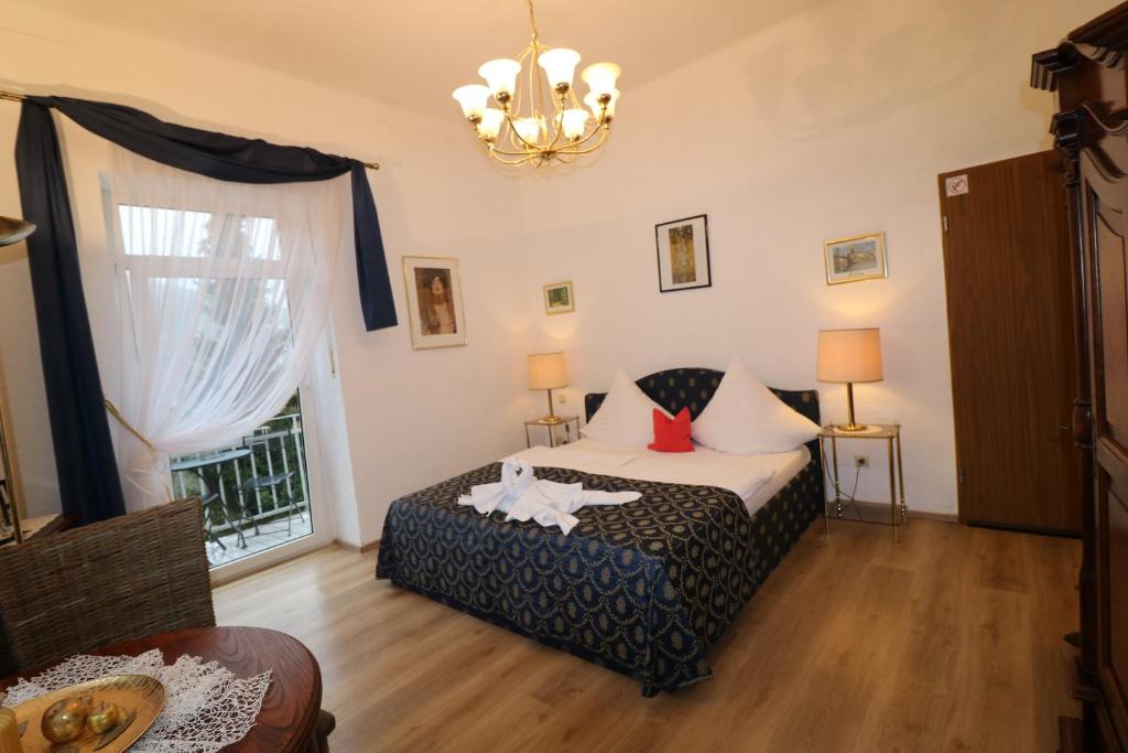 a bedroom with a bed and a window and a chandelier at Villa Amber in Bad Kissingen