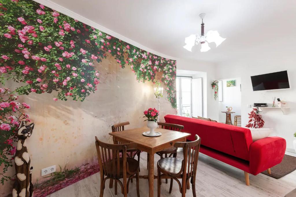 リスボンにあるThe Garden - Charming 1 Bedroom Apartment in Graçaのリビングルーム(テーブル、赤いソファ付)