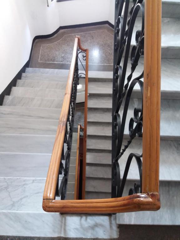 un conjunto de escaleras con barandillas de madera y hierro en Casa della Posta en Borzonasca