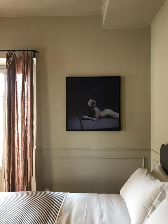 a bedroom with a bed and a tv on the wall at Suites Menaggio in Menaggio