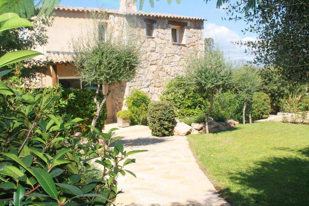 una casa de piedra con una pasarela frente a un patio en Concadoro, en Porto Vecchio