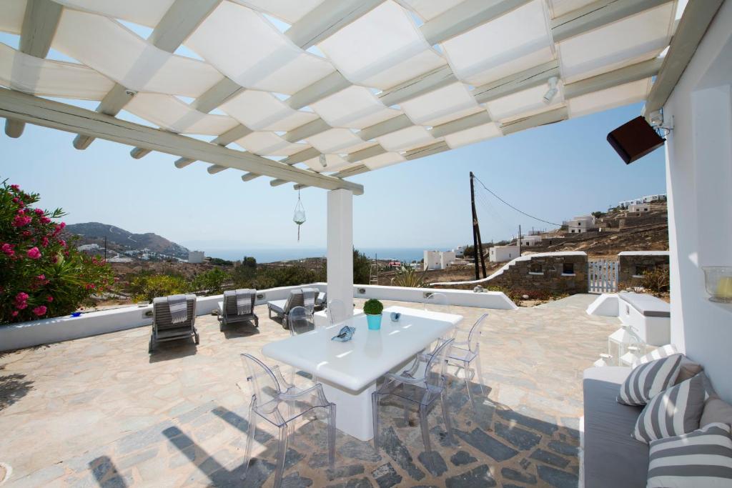a patio with a white table and chairs at Villa Casa Dodo Mare in Elia Beach