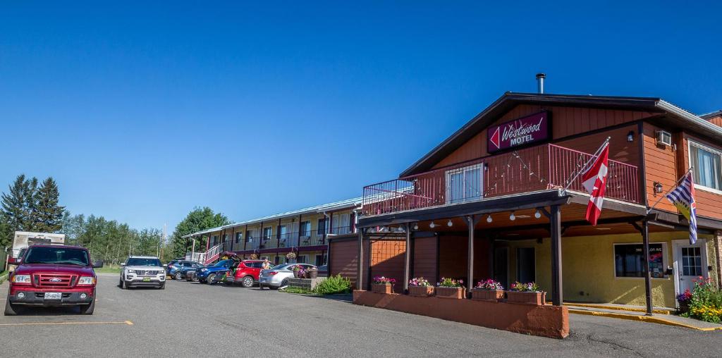 czerwona ciężarówka zaparkowana przed budynkiem w obiekcie Westwood Motel 100 Mile House w mieście One Hundred Mile House