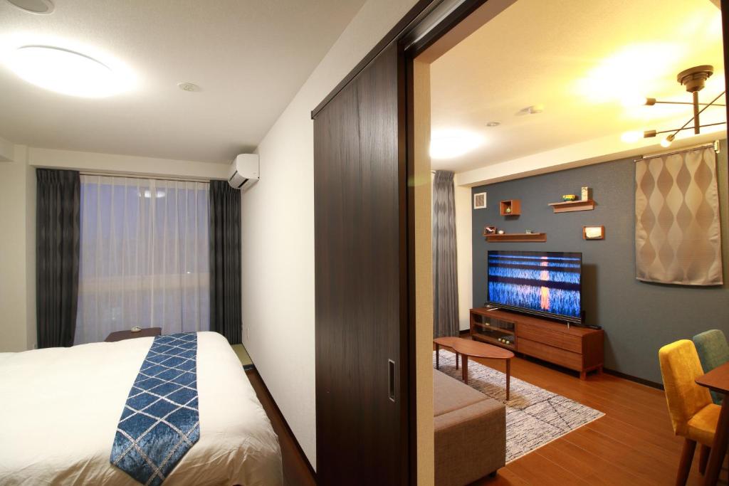 a hotel room with a bed and a television at W&M House in Kanazawa