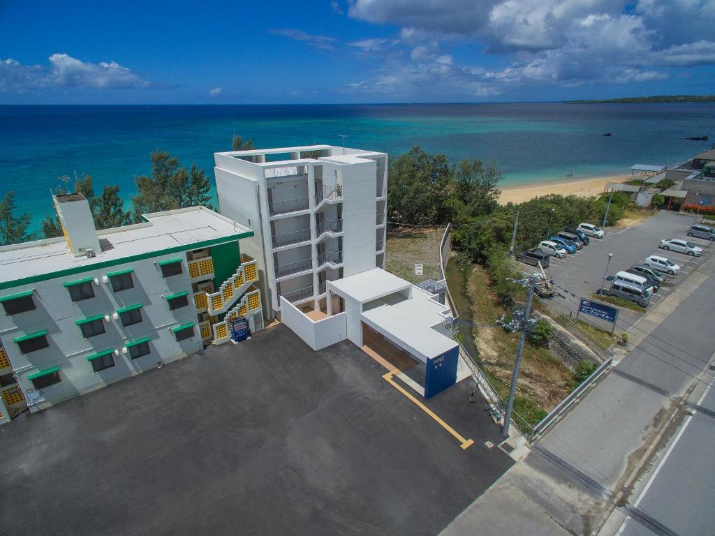 an overhead view of a building with a parking lot and the ocean at Hotel & Restaurant On the Beach Lue in Motobu