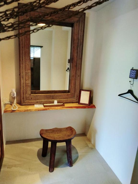 a wooden stool in a room with a mirror at Cenacle B &amp; B in Chenggong