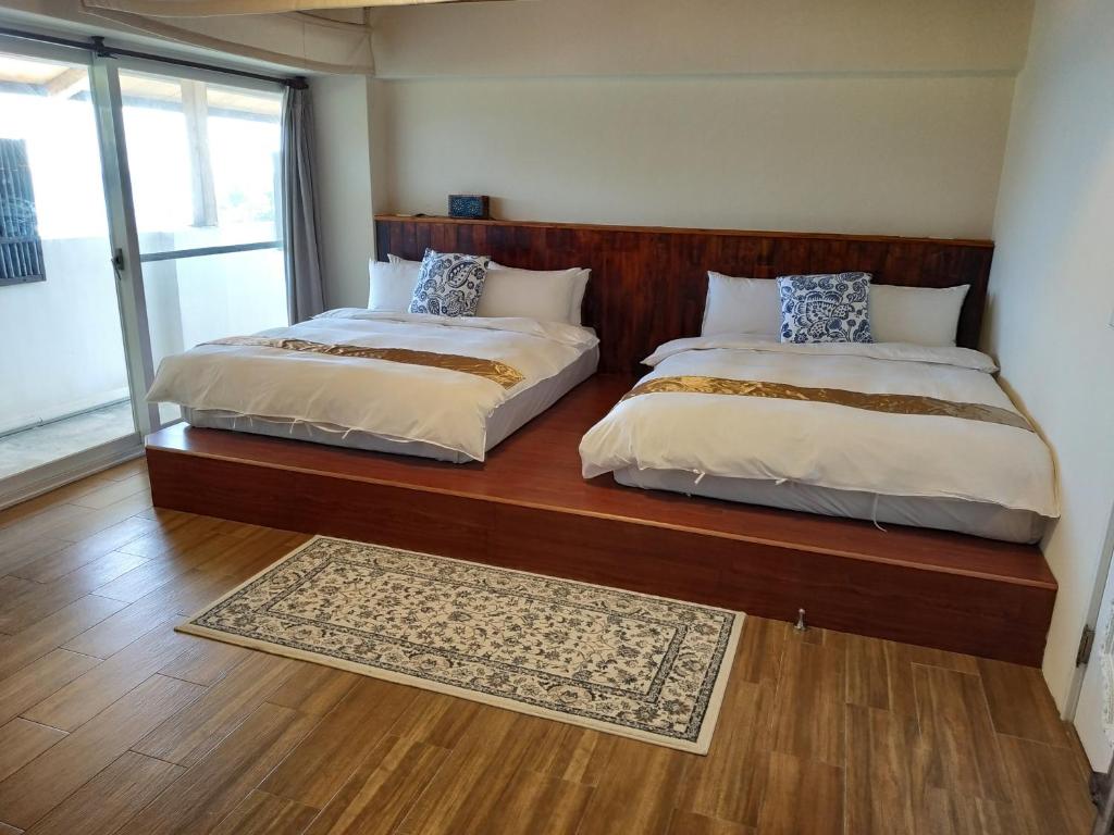 two beds sitting next to each other in a bedroom at Cenacle B &amp; B in Chenggong