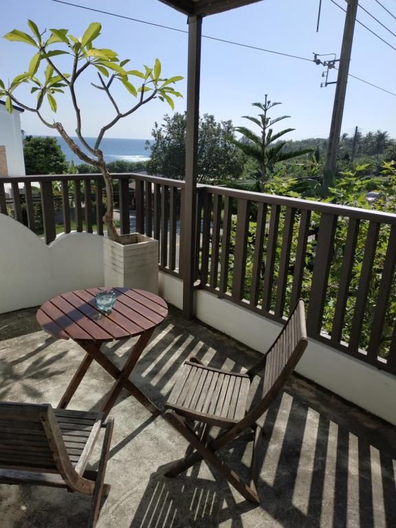 a table and chair on a balcony with a tree at Cenacle B &amp; B in Chenggong