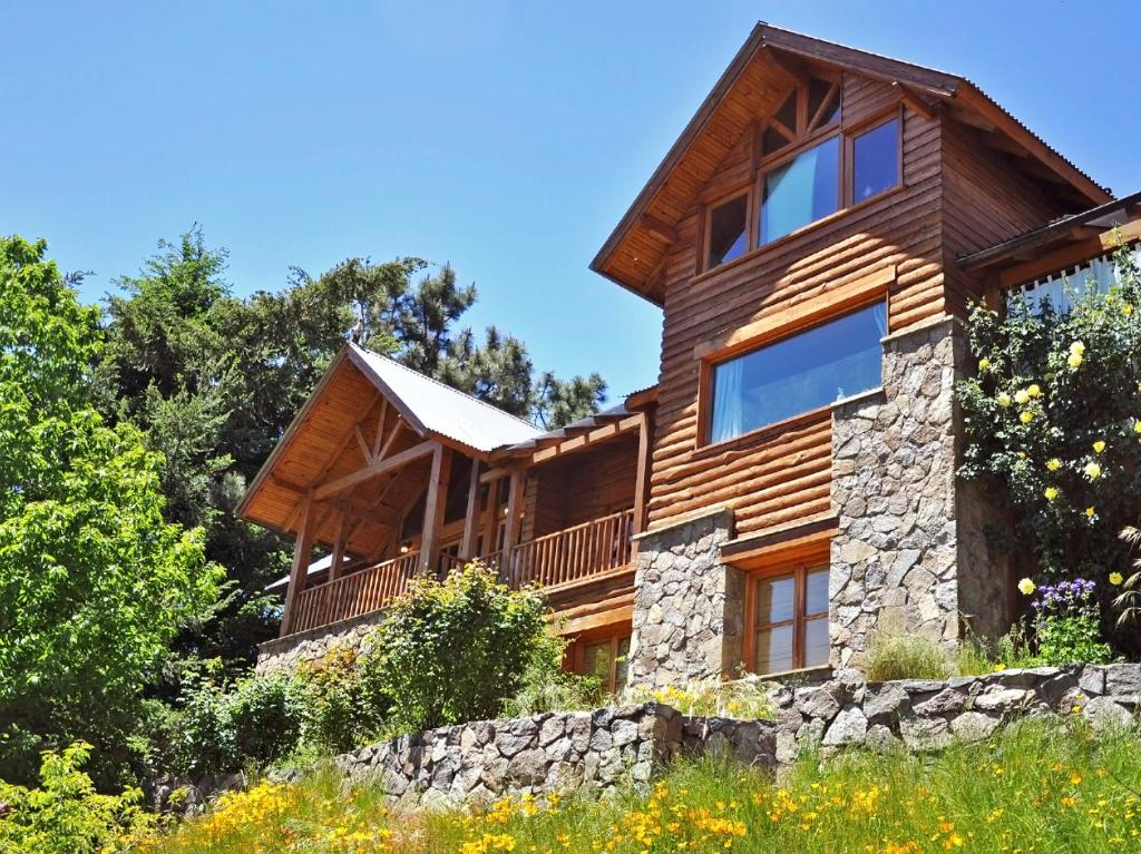 una casa de madera en una colina con árboles en Hostería Bärenhaus en San Martín de los Andes