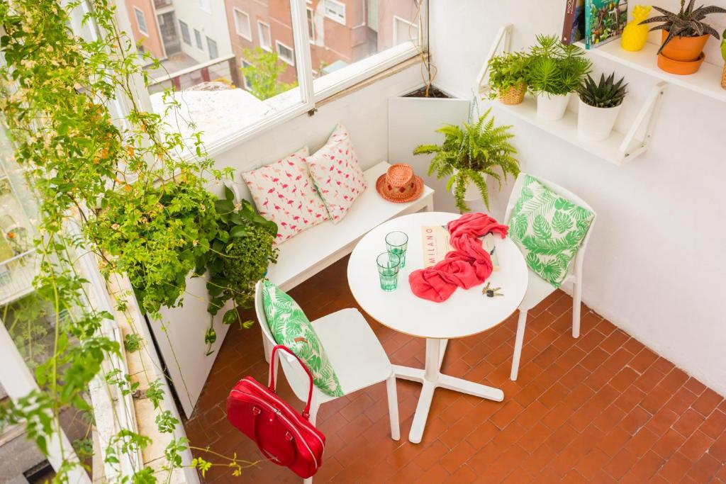 ミラノにあるDuomo Views, Light, Jungle-inspired Studio with Terraceのバルコニー(テーブル、椅子、植物付)