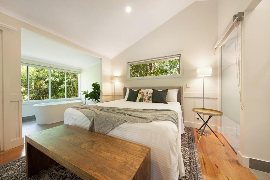 a bedroom with a bed with a wooden table and a bath tub at Clouds Montville in Montville