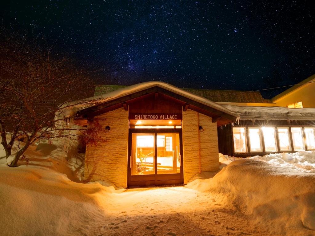 un edificio en la nieve por la noche en Shiretoko Village, en Shari