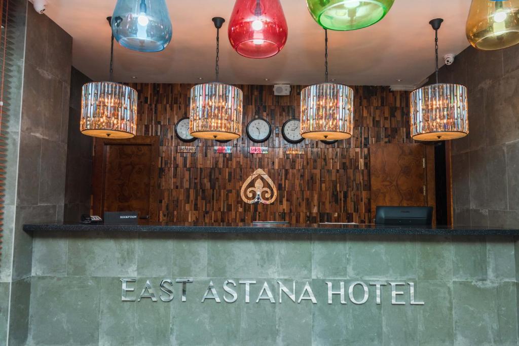 a hotel with chinese lights and clocks on the wall at East Astana Hotel in Astana