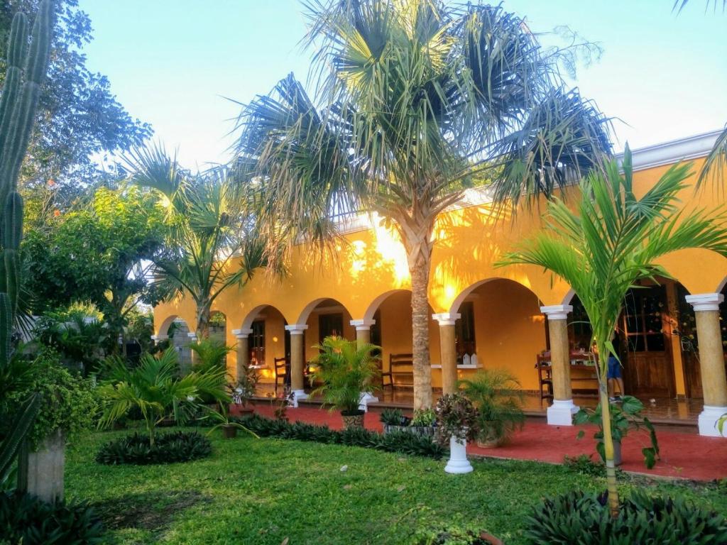 un bâtiment avec des palmiers dans la cour dans l'établissement Casa Palagui Colonial, à Valladolid
