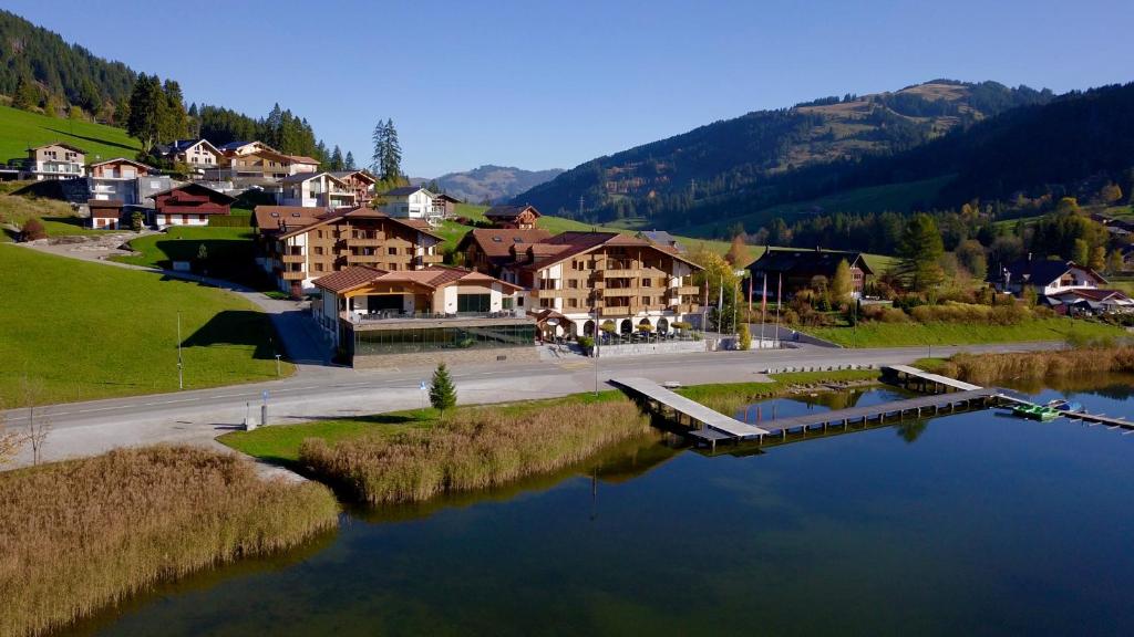 Une ville avec un lac et un tas de bâtiments dans l'établissement Hostellerie am Schwarzsee, à Bad-Schwarzsee