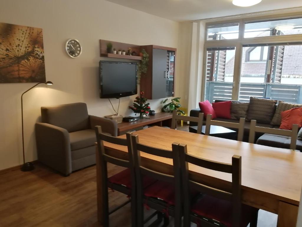 een woonkamer met een tafel en een televisie bij Rodinný Apartmán Harrachov 606 in Harrachov