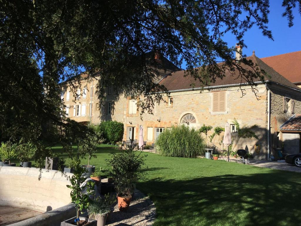 Crémieu的住宿－Villa des Contamines，一座大砖房,有盆栽的院子