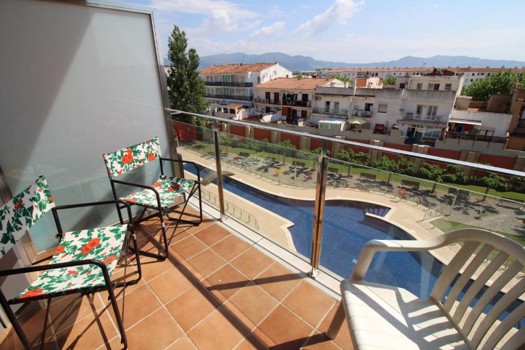 - un balcon avec deux chaises et une piscine dans l'établissement Apart-rent Apartment Puig Rom 0149, à Empuriabrava